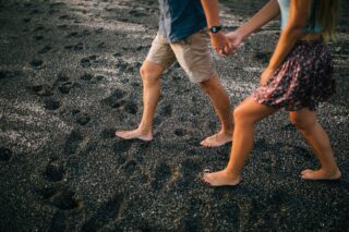 couple walk barefoot in the sand